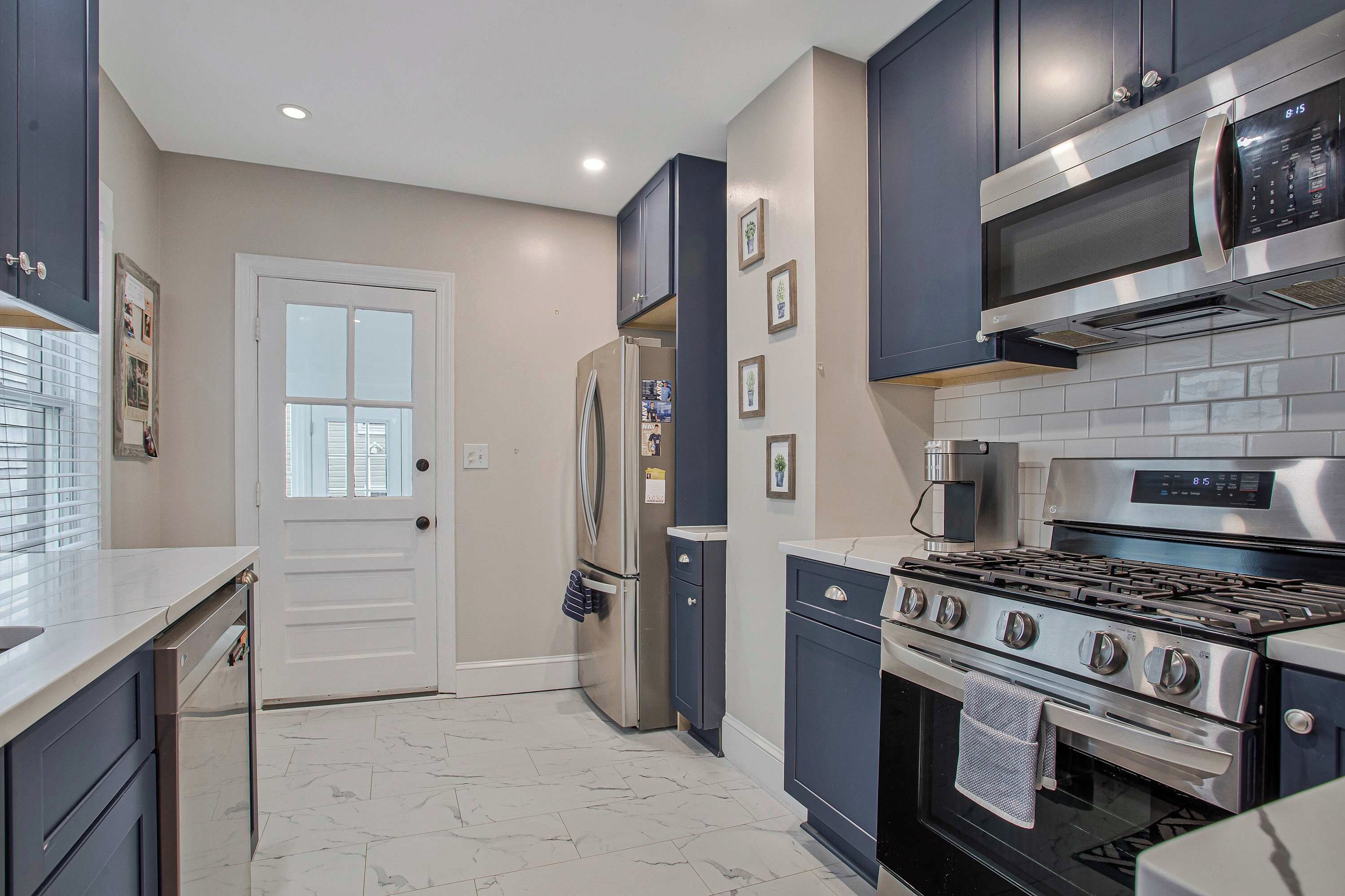 A kitchen with a stainless steel stove, a microwave, and a refrigerator.