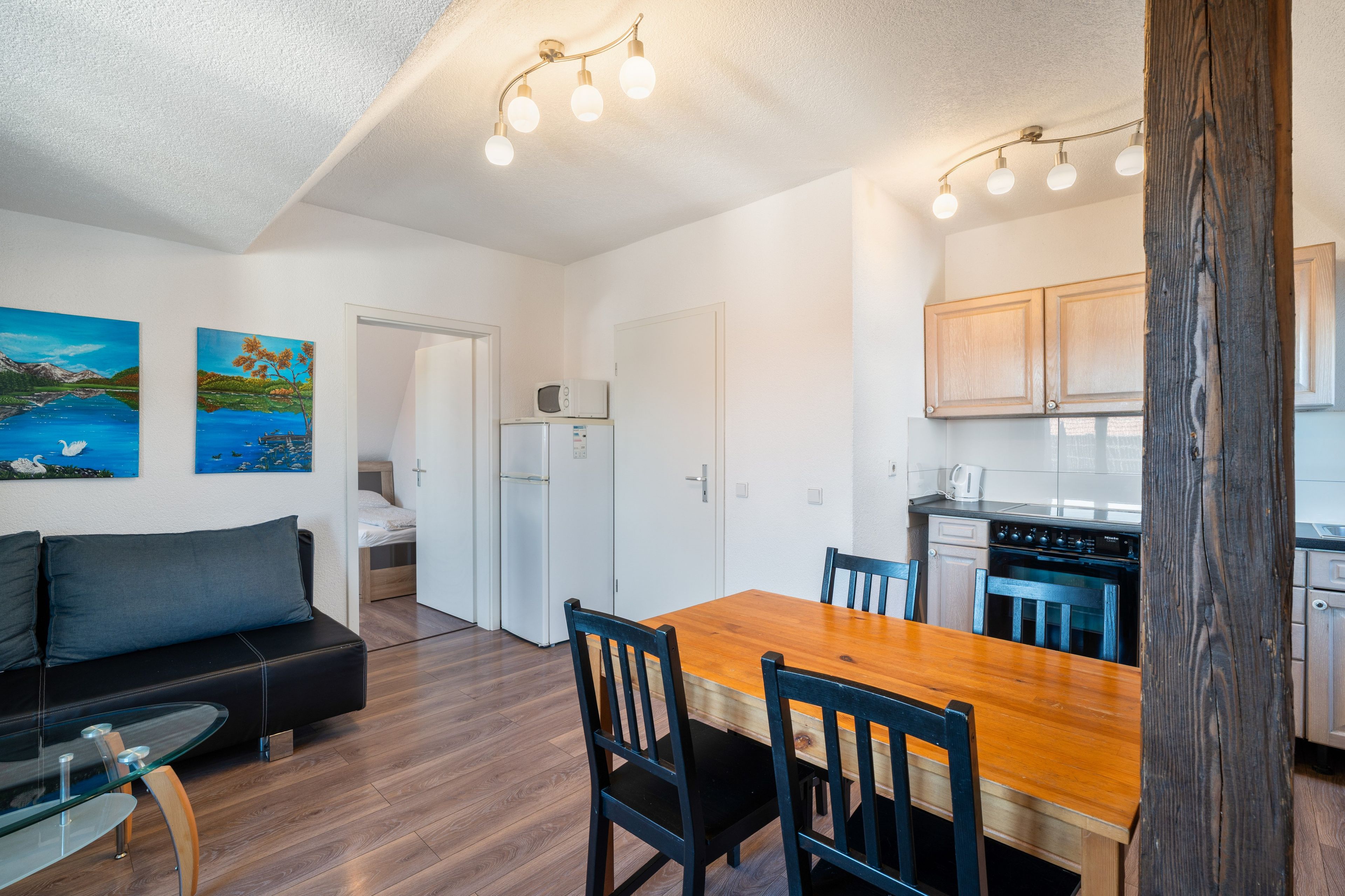 A compact living space with a kitchenette, a dining area, and a sofa.