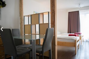 A room with a bed, a glass table, and two chairs. - Neuhausen Holiday Home – Ground Floor Apartment / Wi-Fi / 1 Bedroom (Neuhausen)