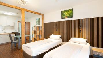 Ein Hotelzimmer mit zwei Betten, einem Schreibtisch, einem Stuhl und einer Wandpaneele aus Holz.