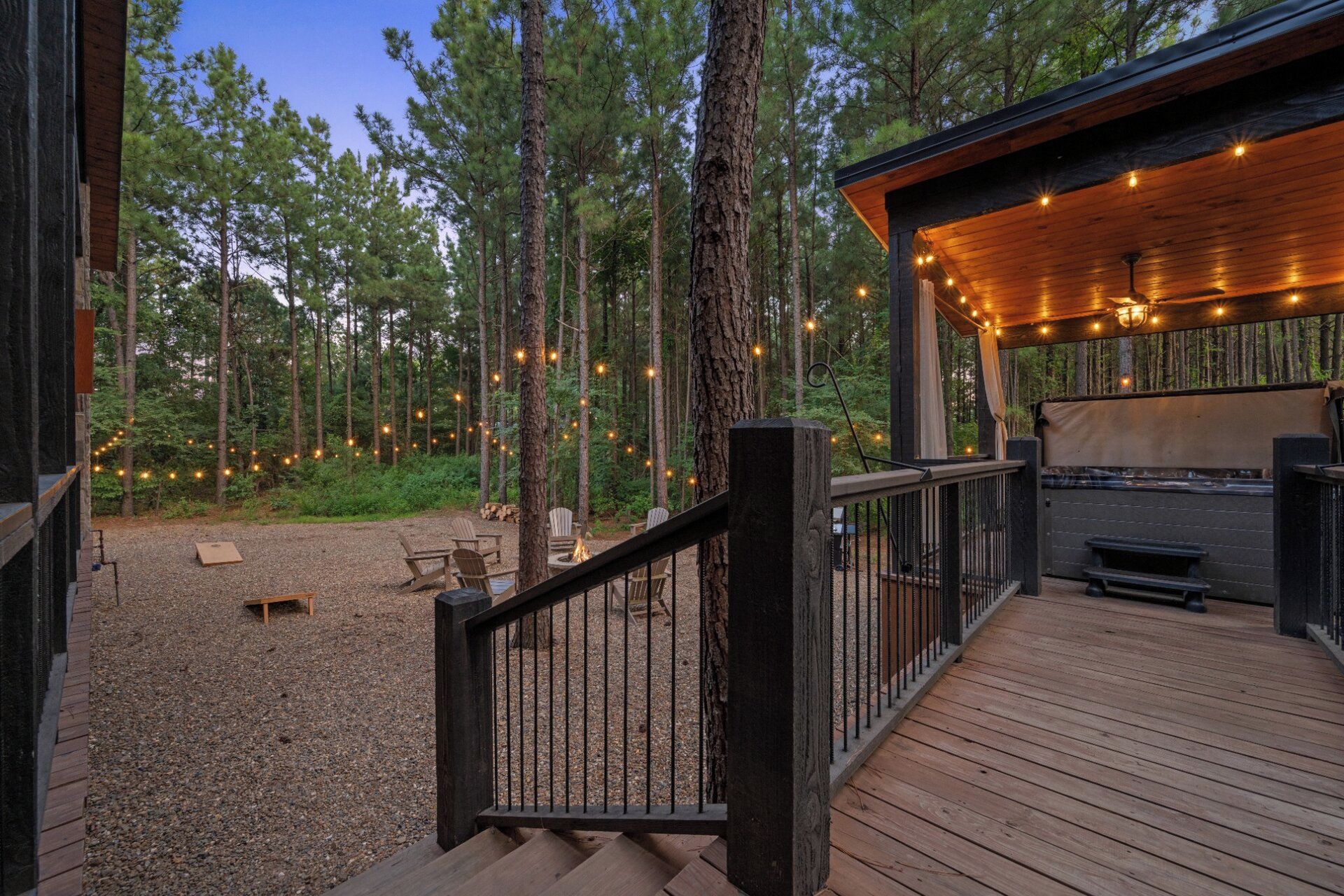 A wooden deck with a railing, surrounded by a forest.