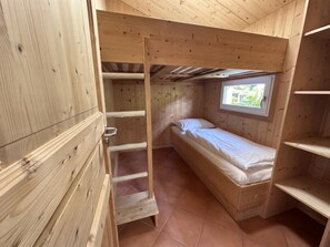 A small wooden room with a single bed, a window, and a wooden ladder. - Cabin in Annaberg With Swimming Pool (Annaberg-Lungoetz)