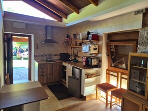 Una cocina compacta con armarios de madera, lavavajillas integrado y una pared de piedra.