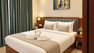 A hotel room with a large bed, a headboard, a nightstand, a lamp, a painting on the wall, and a window with curtains.