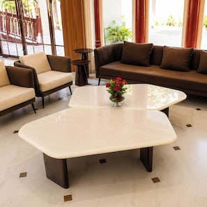 Un hall d’entrée moderne avec un canapé, des fauteuils et une table basse.