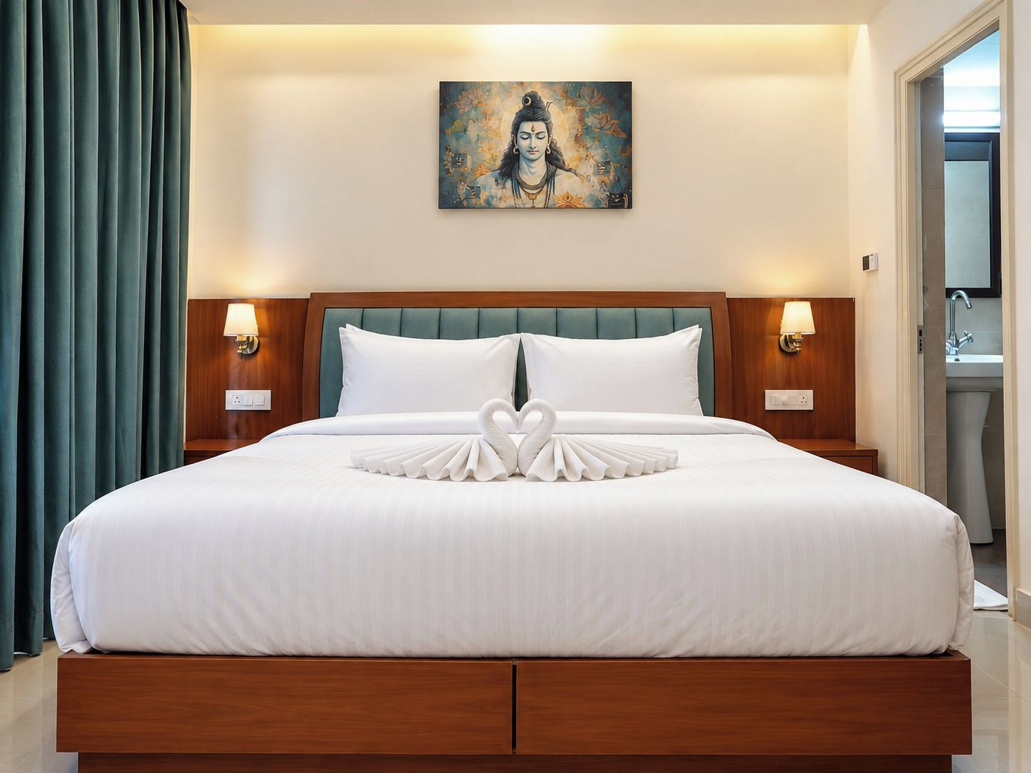 A hotel room with a large bed, a painting on the wall, and a bathroom visible through an open door.