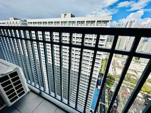 A high-rise building with a view of a cityscape through a balcony railing. - Royal Fame Residence (Mandaluyong)