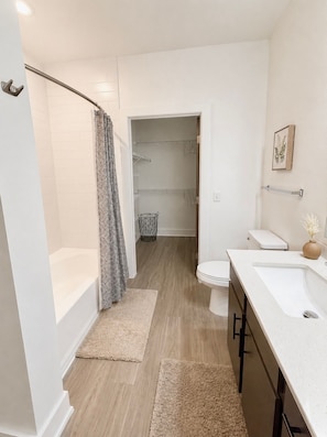 Un bagno moderno con vasca, water e lavabo.