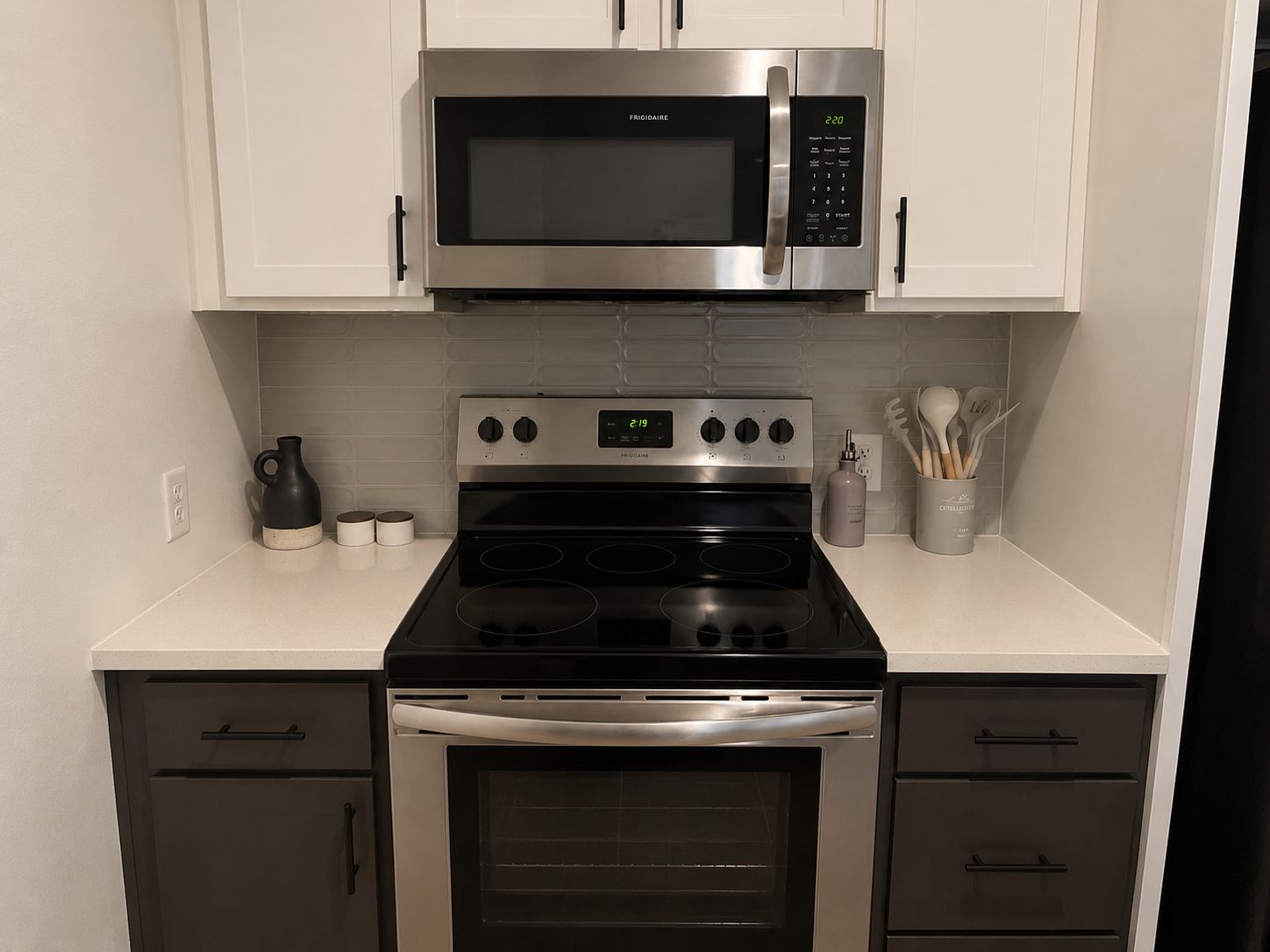 Une cuisine moderne équipée d’appareils électroménagers en acier inoxydable, notamment un four à micro-ondes, un four et une cuisinière.