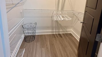 A storage closet with metal shelving units and a metal basket.