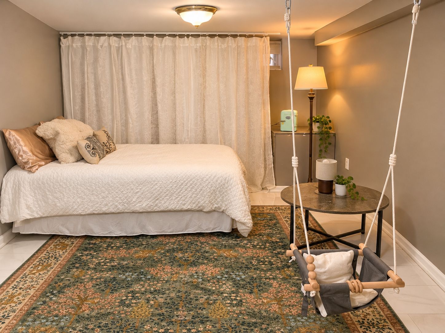 Une chambre à coucher avec un lit, un fauteuil suspendu, une lampe et une petite table sur laquelle est posée une plante.
