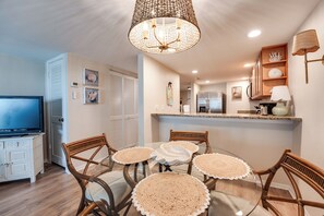 Una cocina moderna con comedor, muebles de madera y televisión.