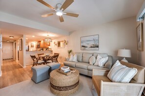 Ein modernes Wohnzimmer mit einer Couch, einem Couchtisch und einem Deckenventilator.