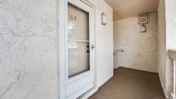 A corridor with a white door labeled 'G5' and an exit sign. - 2-bedroom Condo in St. Augustine- Private Beach Beach Access + Pool! (St. Augustine)