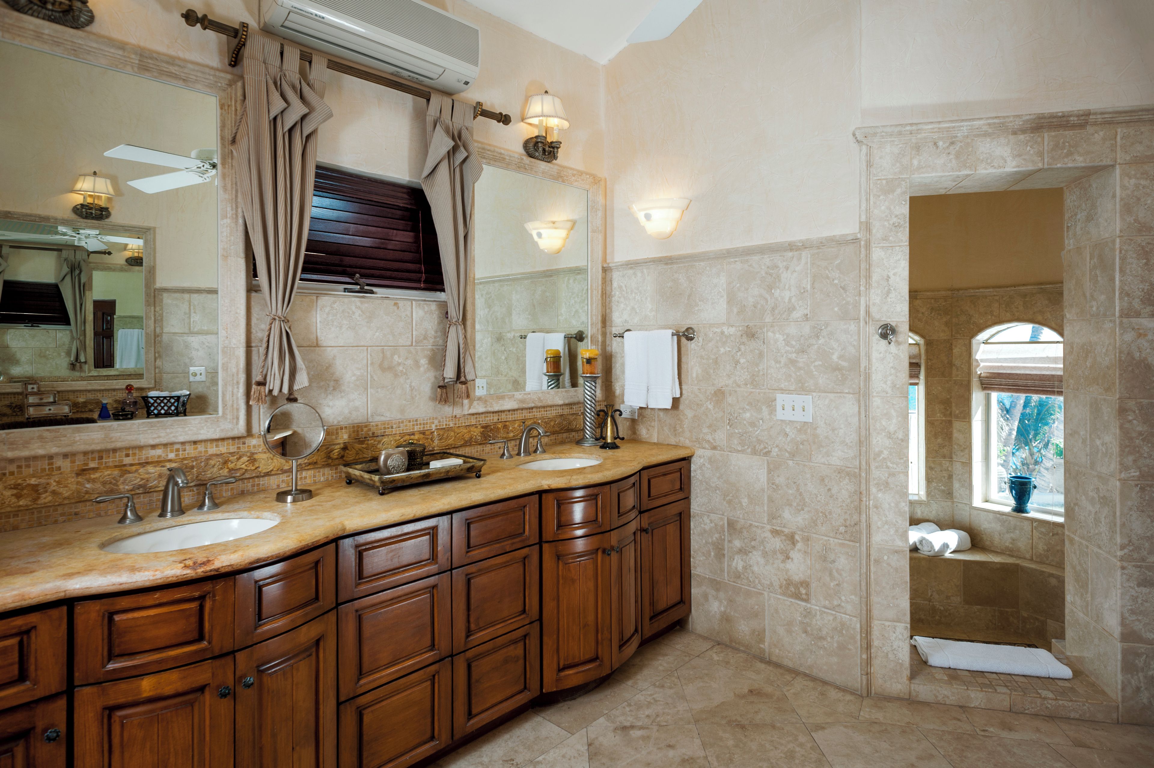 A bathroom with a double sink vanity, a large mirror, and a towel rack.