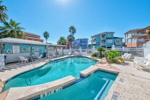 A swimming pool with a 3 FT 6 IN depth marker, surrounded by lounge chairs and a white fence. - Tan Lines and Fine Wines (Port Aransas)
