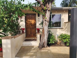 A house with a wooden door, a small porch, and potted plants. - Comfy Courtyard 1 Bedroom at Jackson Market (Culver City)