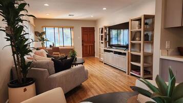 A modern living room with a sofa, a coffee table, and a TV stand.