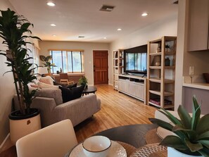 A modern living room with a sofa, a coffee table, and a TV stand. - Comfy Courtyard 1 Bedroom at Jackson Market (Culver City)
