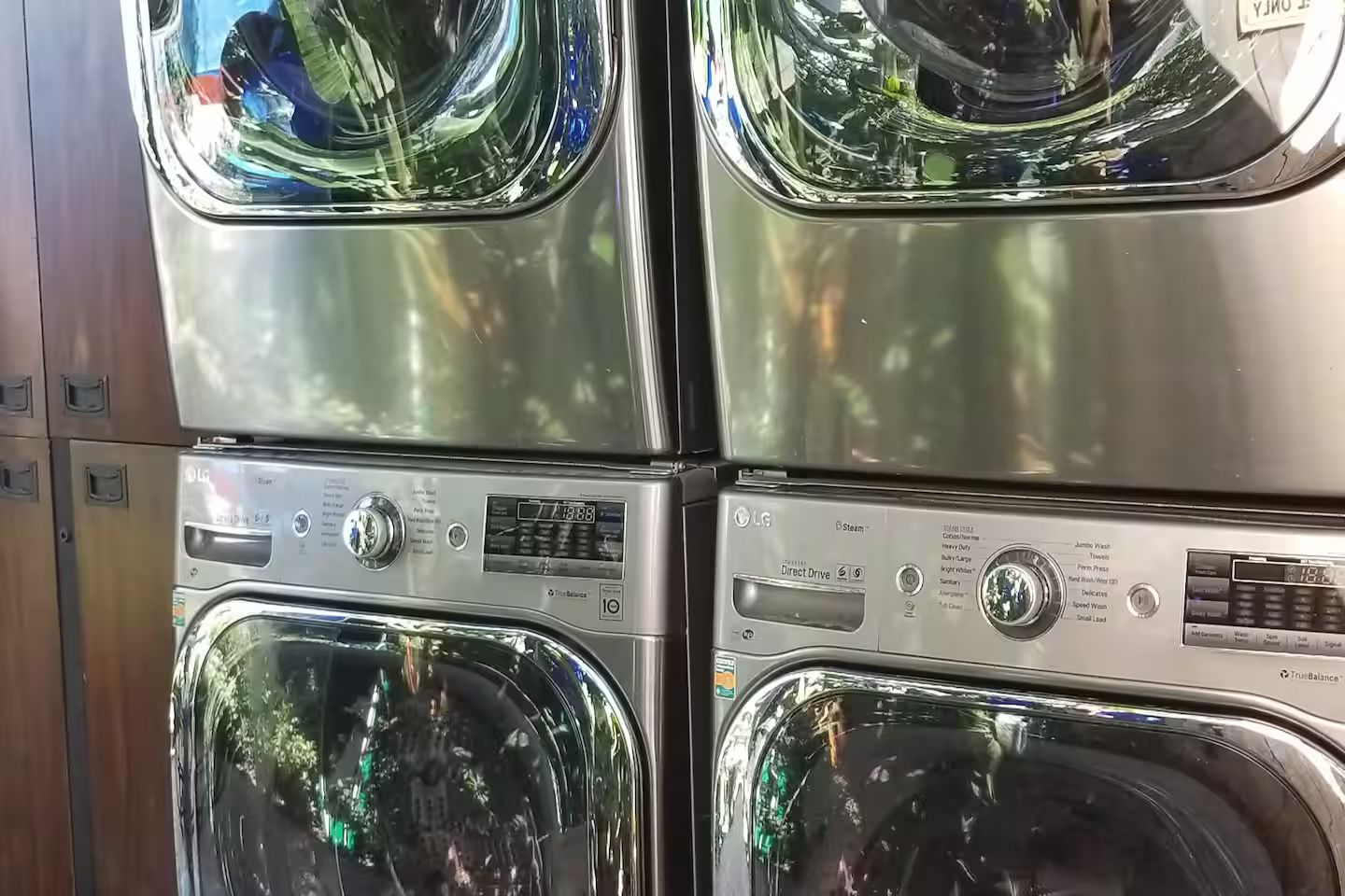 A stack of four washing machines with control panels, each featuring various settings and buttons.
