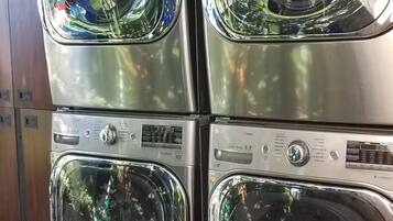 A stack of four washing machines with control panels, each featuring various settings and buttons.