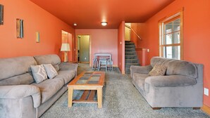 A living room with two sofas, a coffee table, and a staircase leading to an upper level. - Mineral Mountain Lodge in Gilded Mountain (Lead)