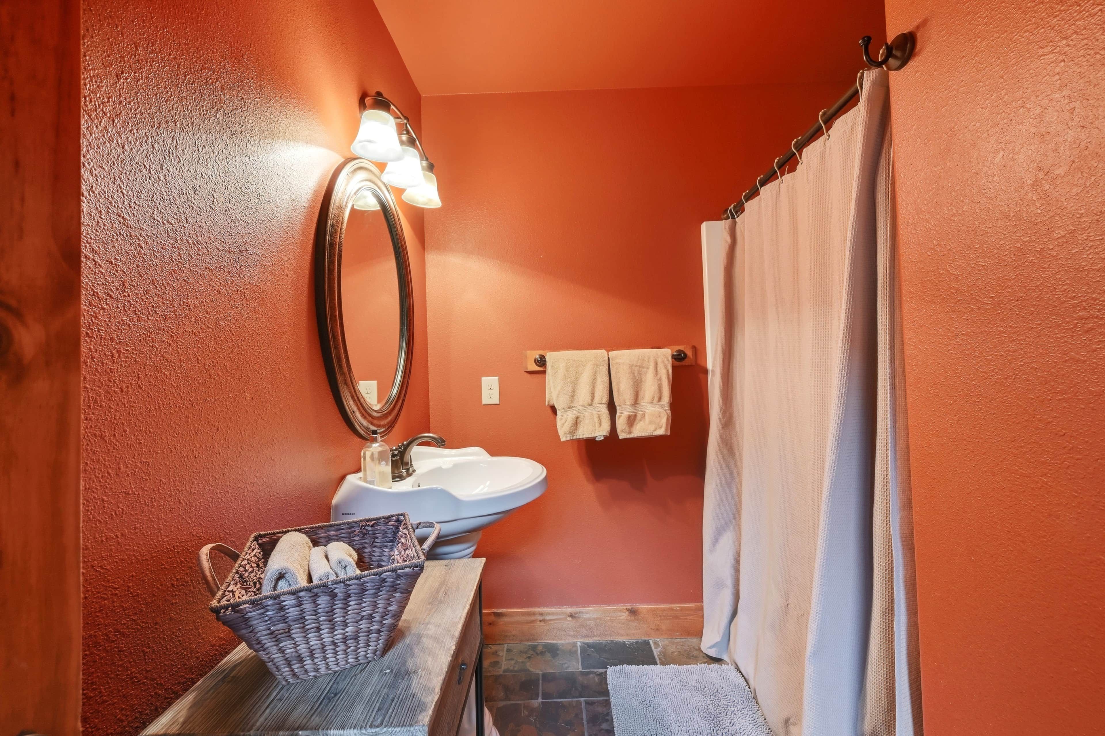 A bathroom with a sink, mirror, and a towel rack.