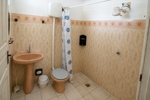 A bathroom with a sink, toilet, and shower curtain.