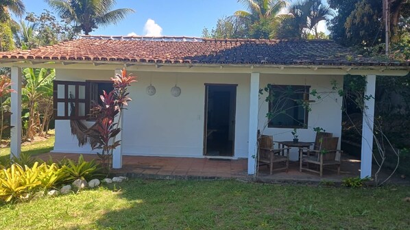 A single-story house with a tiled roof, a covered porch, and a small patio area.