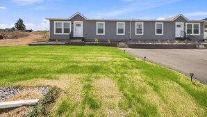 A residential building with a flat roof, multiple windows, and a paved driveway. - NEW Modern Contemporary West Side Retreat (Colorado Springs)