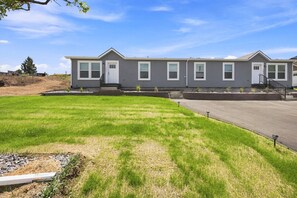 A residential building with a flat roof, multiple windows, and a paved driveway. - NEW Modern Contemporary West Side Retreat (Colorado Springs)
