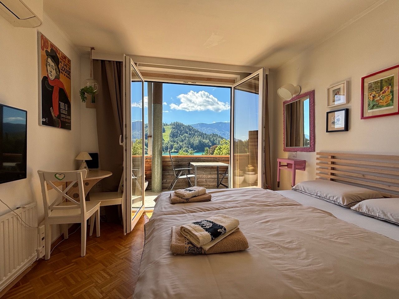 Un dormitorio con una cama grande, un escritorio y vistas a un paisaje montañoso.