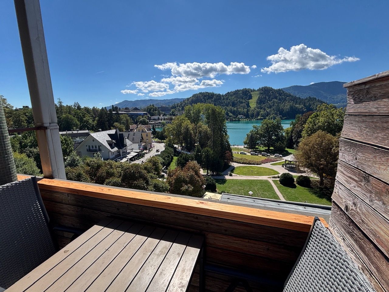 Un balcon avec vue sur un lac, des bâtiments et une montagne en arrière-plan.