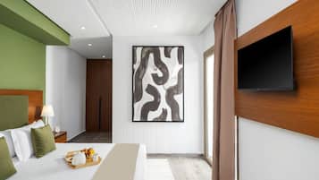 Habitación de hotel moderna con cama, televisor de pantalla plana en la pared, un cuadro abstracto grande y cabecero de madera.