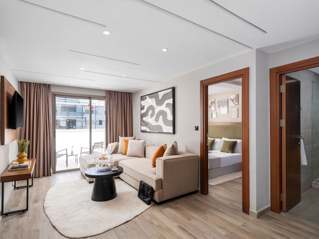 Habitació d'hotel moderna amb un sofà, una taula de cafè i un llit.