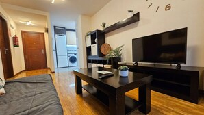 Een moderne woonkamer met een bank, een salontafel, een televisie en een inbouwmeubel.