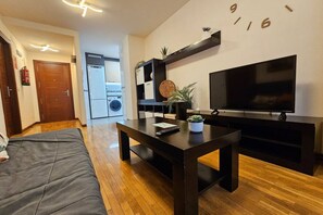 Una sala de estar moderna con un sofá, una mesa de centro, un televisor y un mueble empotrado para entretenimiento.