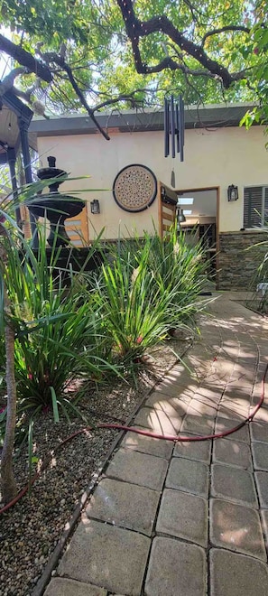 A garden pathway with a stone border, a water feature, and a decorative wall plate. - Skylight Studio at Jackson Market (Culver City)