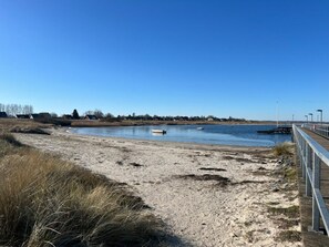 A sandy beach with a wooden boardwalk leading to a calm body of water. - Holiday Apartment With 1 Bedroom (Wendtorf)