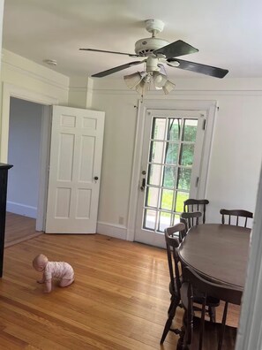 A dining area with a ceiling fan, a wooden table, and chairs. - Cozy Vermont retreat near Jay peak (Troy)