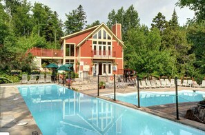 Ein zweistöckiges Gebäude mit Swimmingpool, umgeben von Bäumen.