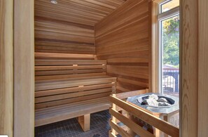 Ein Saunaraum mit Holzbänken und einem kleinen Tisch mit einem Handtuch.