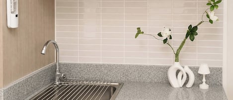 A kitchen with a stainless steel sink, a water filtration system, and a vase with flowers.
