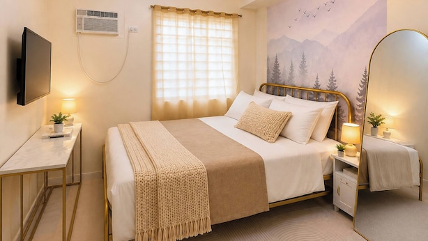 A bedroom with a bed, bedside tables, a TV, a window with curtains, a wall mural, and a mirror. - The Sky Nook Cubao Near Gateway & MRT (Quezon City)
