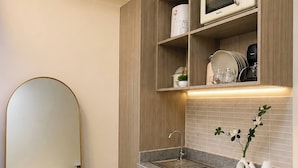 A modern kitchen with a built-in microwave, a sink, and a mirror. - The Sky Nook Cubao Near Gateway & MRT (Quezon City)