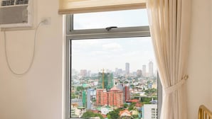 A hotel room with a bed, a window with curtains, and an air conditioning unit on the wall. - The Sky Nook Cubao Near Gateway & MRT (Quezon City)
