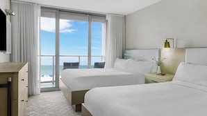 A hotel room with two beds, a desk, a nightstand, and a view of the beach. - Marriott's Crystal Shores 2 Bedroom Villa With Full Resort Access (Marco Island)