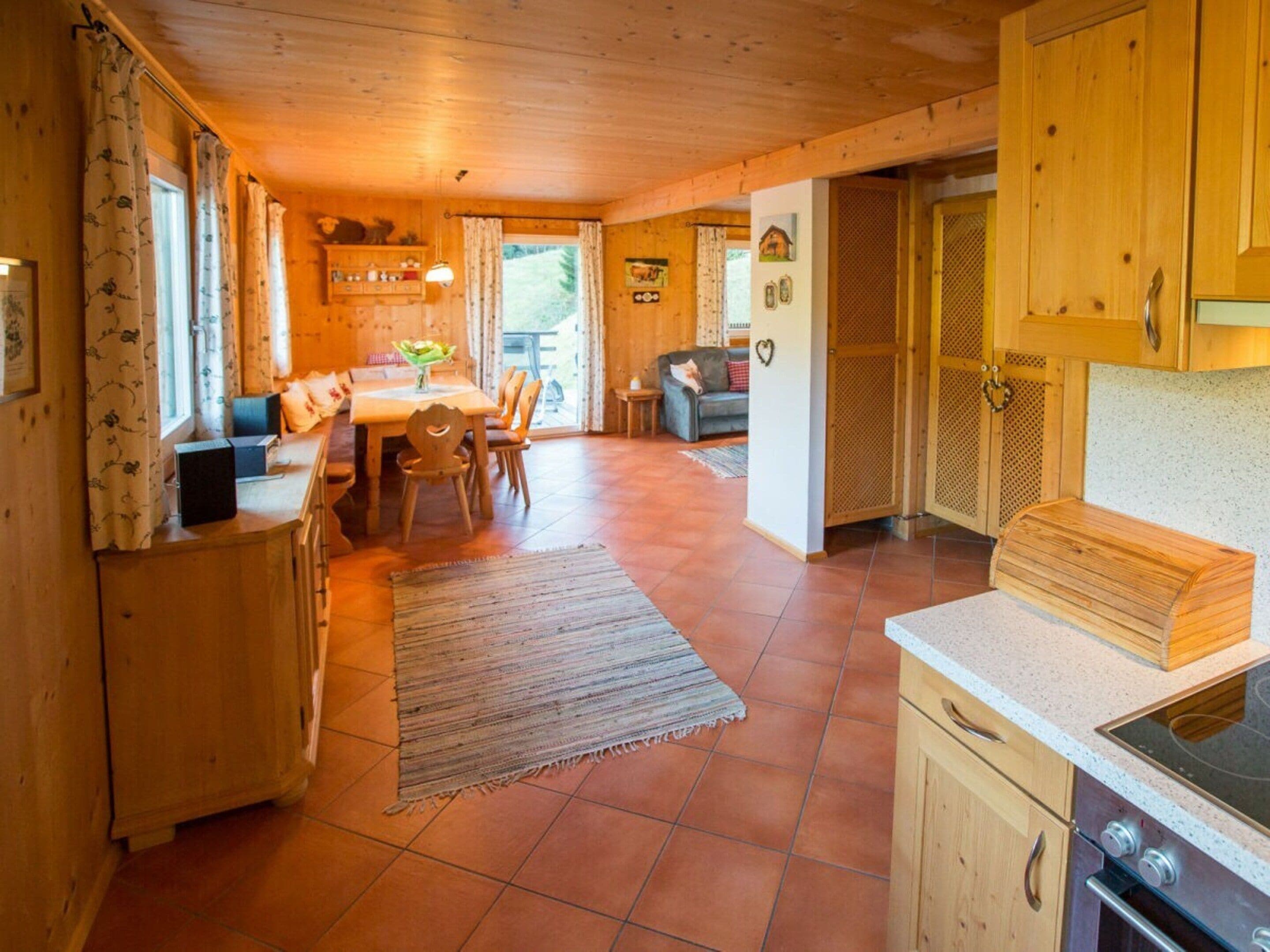 A wooden interior with a dining area, kitchen, and a living space.