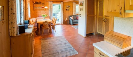 A wooden interior with a dining area, kitchen, and a living space.