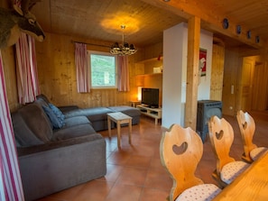 A cozy cabin interior with a sofa, wooden chairs, a television, and a fireplace. - Cabin in Annaberg With Swimming Pool (Annaberg-Lungoetz)